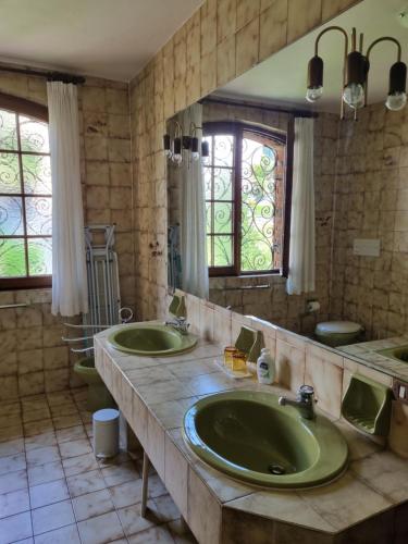 a bathroom with two sinks and a large mirror at Glicine in Carlazzo