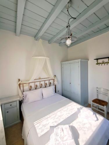 a bedroom with a white bed and a ceiling at KLIMA apartment in Perdika