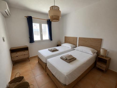 a bedroom with two beds and a window at 6 person house with private pool and garden in Trebeluger