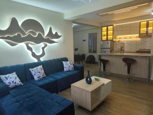 a living room with a blue couch and a kitchen at DEPPIu in Piura