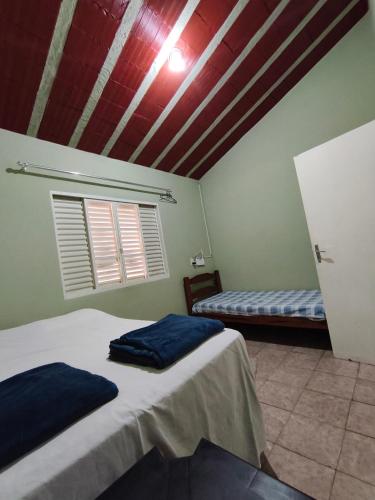 a room with two beds in a room with a ceiling at Chácara Angola in Andradas