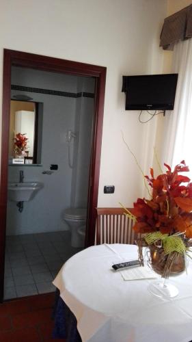 a bathroom with a table with a vase of flowers on it at Corte Degli Estensi in Formigine