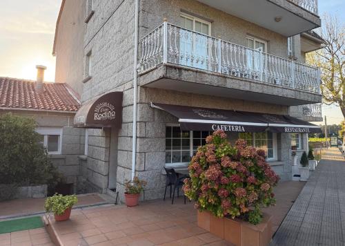 a building with a balcony and flowers in front of it at Casa Rodiño in Meaño