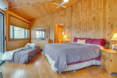 a bedroom with two beds and a wooden wall at Dock & Beach Access: Scenic Lake Ossipee Cabin! in Center Ossipee