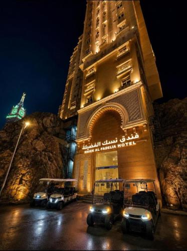 a building with cars parked in front of it at night at فندق نسك الفضيلة in Ajyad