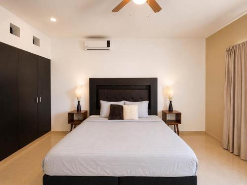 a bedroom with a large white bed with two night stands at Encanto Riviera in Playa del Carmen