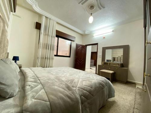 a bedroom with a bed and a dresser and a mirror at بوابة جرش Jarash Gate in Jerash