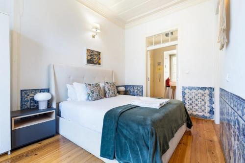 a bedroom with a large white bed with blue accents at Gonzalo's Guest Apartments - Downtown Historic Flats in Lisbon