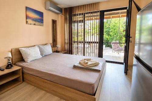 a bedroom with a bed and a balcony at Black Sea Pearl in Krapets