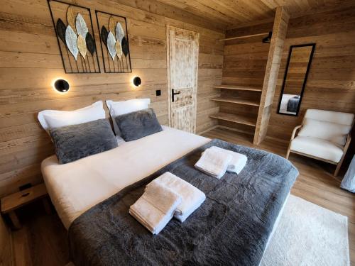 a bedroom with a large bed in a wooden room at Les 2 Chalets Alpins & Bains Nordiques in Saint-Michel-de-Chaillol