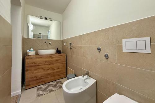 a bathroom with a toilet and a sink and a mirror at La Maison Fleurie in San Nicola Arcella