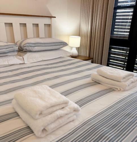 a bedroom with two beds with towels on them at 33D Kabeljauws Beach in Jeffreys Bay