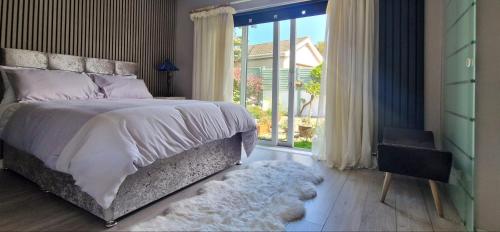 a bedroom with a bed and a large window at Coastal Harmony B&B in Portstewart