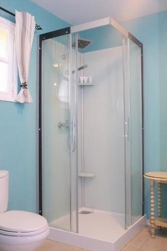 La salle de bains est pourvue d'une douche en verre et de toilettes. dans l'établissement Le Douitel, à Roncey