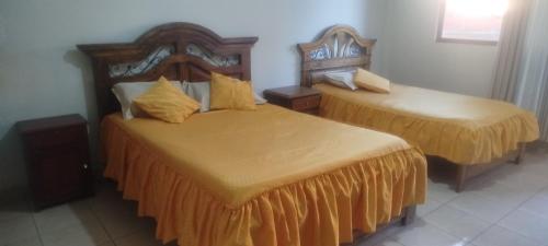 two beds in a hotel room with two beds at Hostal Cadena in Tupiza