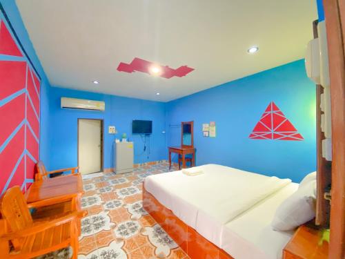 a blue bedroom with a bed and a blue wall at โชติอนุสรณ์ รีสอร์ท ชุมพร in Ban Bang Mak (1)