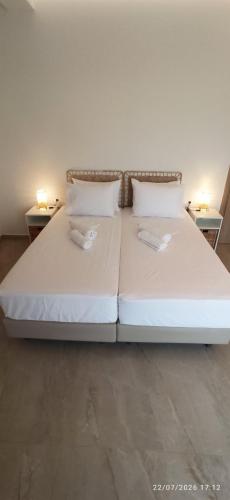 a large white bed with two pillows and two tables at Casa Ligoustra in Kalithies
