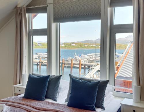 a bedroom with a large window with a view of a harbor at Modern seafront cabin with sauna 8 mins to Leknes in Storeidet