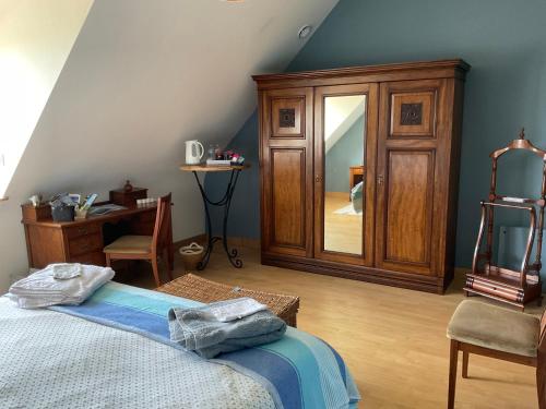 a bedroom with a bed and a mirror and a desk at Ti Toenn et spa in Landéda