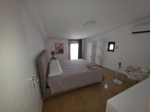 a white bedroom with a bed and a window at MARE FUORI LUXURY B&b in Cassano delle Murge