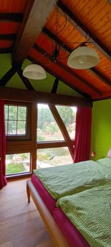 a bedroom with a bed in a room with windows at Haus Rothenberg - Wohnung Anne in Nohfelden