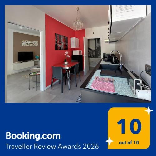 a kitchen and dining room with a red wall at Design apartment n. 41 in Trento