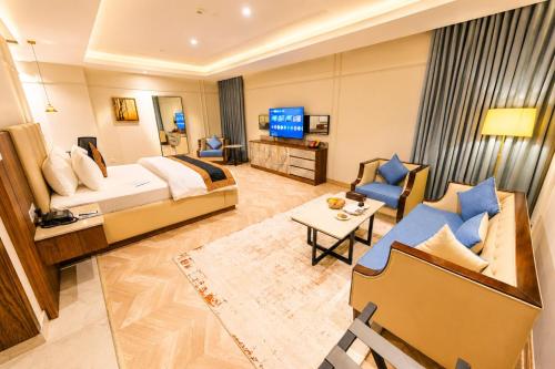 a hotel room with a bed and a living room at Hotel Space Crest in Faisalabad