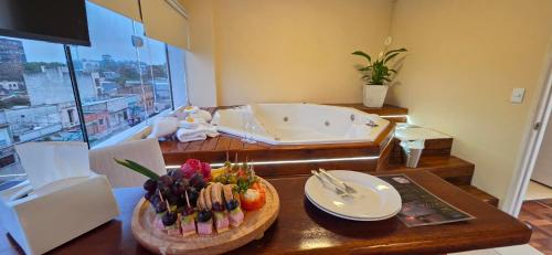 ein Tisch mit einer Schüssel Essen und eine Badewanne in der Unterkunft Nuevo Hotel in Rivera