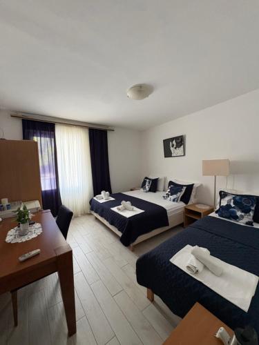 a hotel room with two beds and a table at Apartments Boras in Cavtat