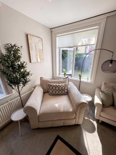 a living room with a couch and a chair at Bright 2-Bed Garden Flat Central Guildford in Purley