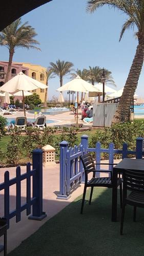 a blue fence with a table and chairs next to a pool at ساوث بيتش بورتو السخنه in Ain Sokhna