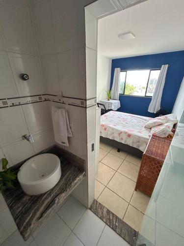 a bathroom with a toilet and a bed with a window at Salvador Backpackers House in Salvador