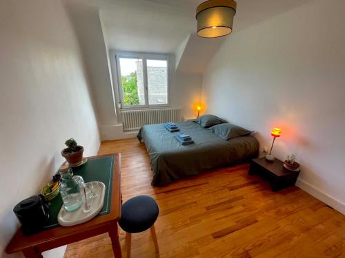 a bedroom with a bed and a table and a window at Le Bercail in Plouézec