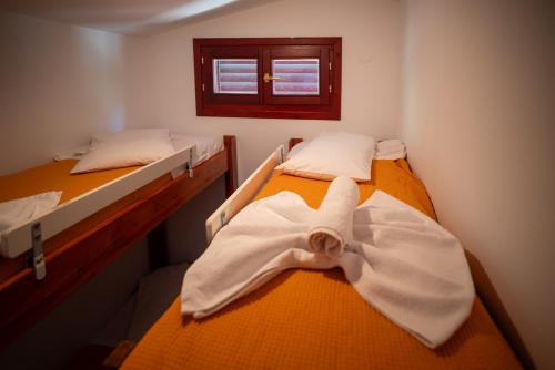 two beds in a room with a bow tie on them at Bungalow - Camping Apollon in Delphi