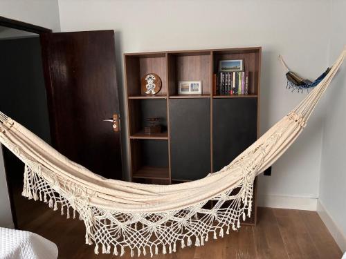 a hammock in a room with a book shelf at Fully equipped house - 7 guests in Petrolina
