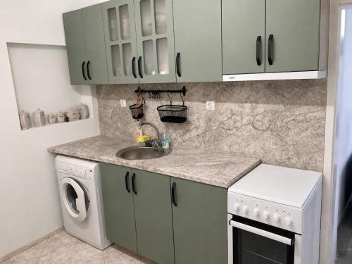 a kitchen with a sink and a washing machine at Saltywind House in Pomorie