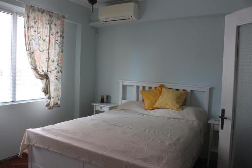 a bedroom with a bed with yellow pillows and a window at Saltywind House in Pomorie