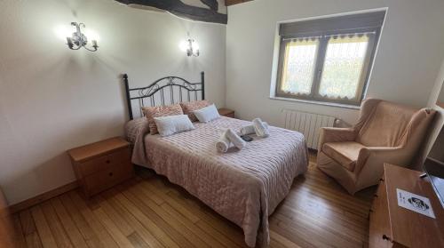 a bedroom with a bed and a chair at Caserio EL AJO in Herrán