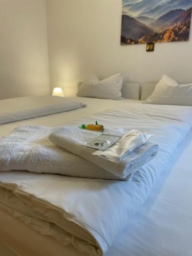 a white bed with a towel on top of it at Hotel Starlight in Frankfurt