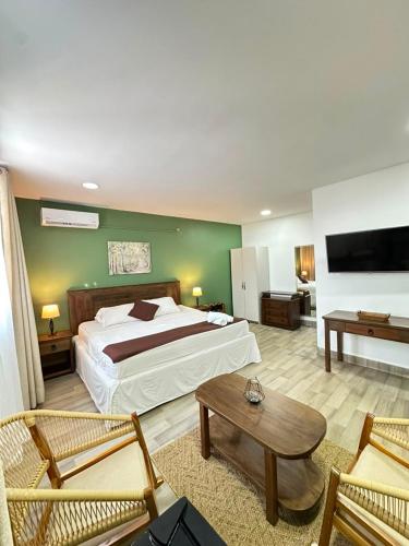 a bedroom with a bed and a couch and a table at Santa Alejandría Hotel in Cartagena de Indias