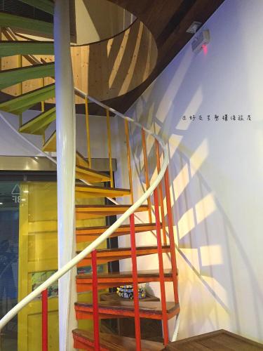 a wooden staircase in a room with a wall at True-FDs Inn in Xiaoliuqiu