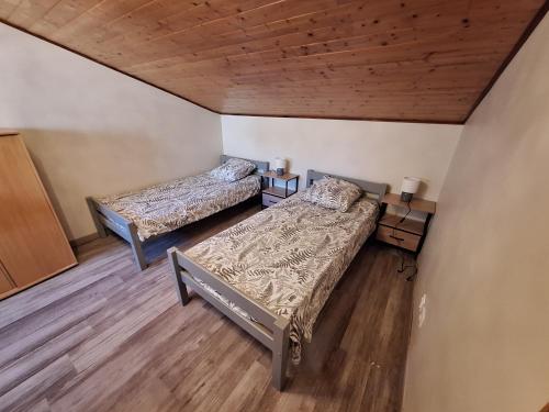 two beds in a room with wooden floors at Gite de la véore in Chabeuil