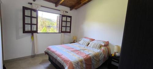 a bedroom with a bed and a window at Cálida Casa con amplio espacio verde en Raco in Raco