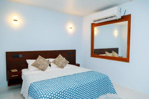 a bedroom with a large bed and a mirror at Midtown Mansion in Veyangoda