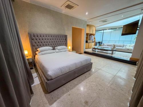 a bedroom with a large bed and a living room at Silva Villa in Bedfordview