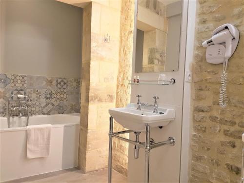 a bathroom with a sink and a bath tub at Le Tardif, Noble Guesthouse in Bayeux