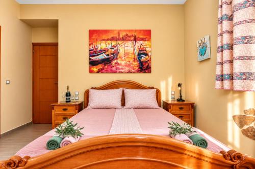 a bedroom with a wooden bed and a painting on the wall at Casa Adam and spa in Zakynthos