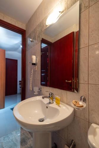 a bathroom with a white sink and a mirror at Bungalow - Camping Apollon in Delphi