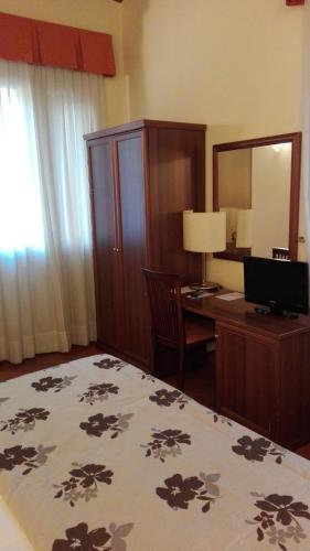 a bedroom with a bed and a desk with a computer at Corte Degli Estensi in Formigine