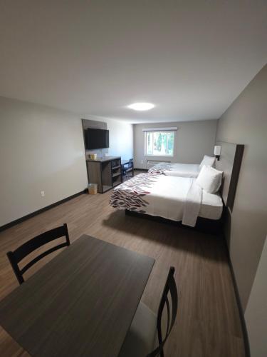 a bedroom with a bed and a table in a room at Red Roof Inn Sutton in Sutton